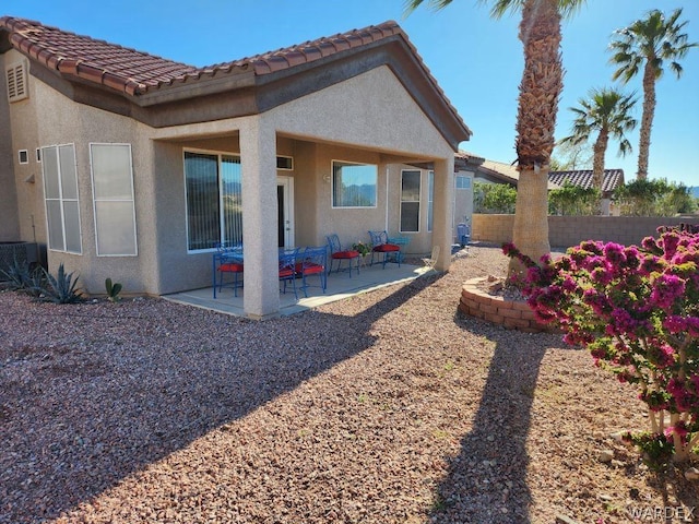 back of property with a patio area, a tile roof, fence, and stucco siding