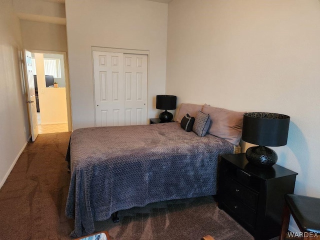 bedroom featuring a closet, dark carpet, and baseboards