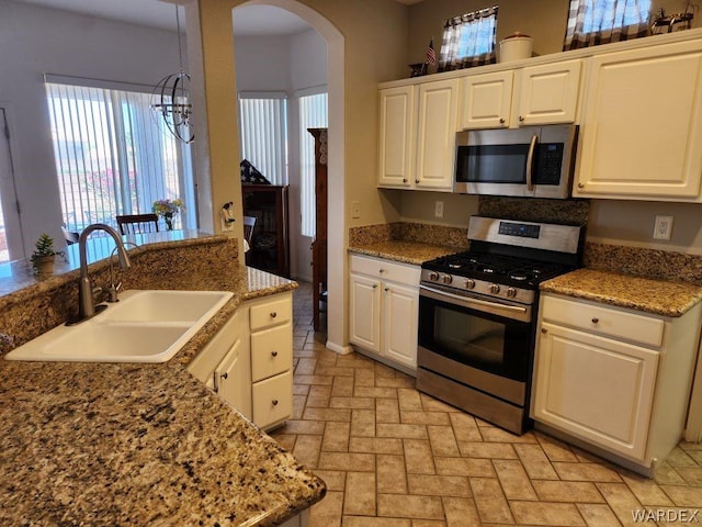 kitchen with appliances with stainless steel finishes, white cabinets, and a sink