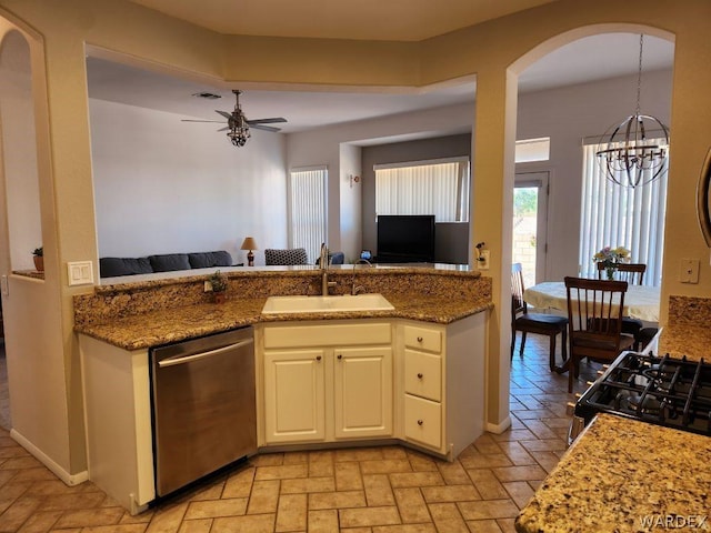 kitchen featuring stone countertops, a sink, white cabinets, open floor plan, and dishwasher