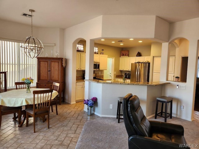 dining room featuring arched walkways, recessed lighting, visible vents, and a notable chandelier