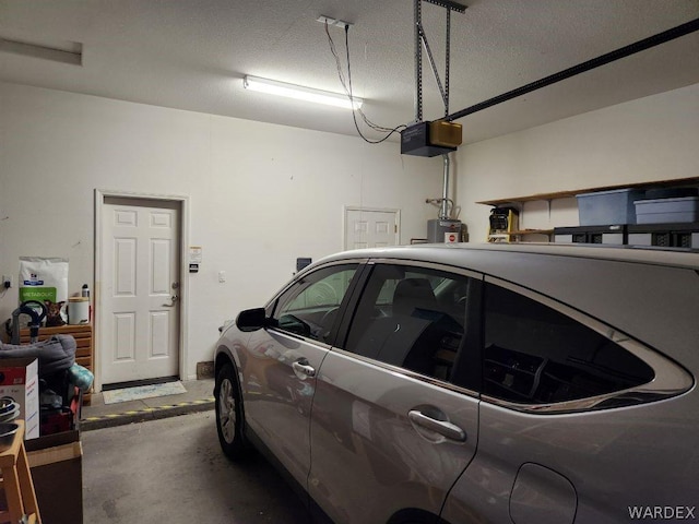 garage featuring water heater and a garage door opener