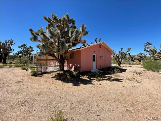 view of side of property with an outbuilding and fence