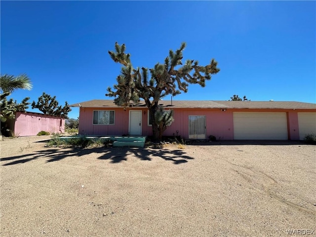 ranch-style home featuring driveway, an attached garage, and fence