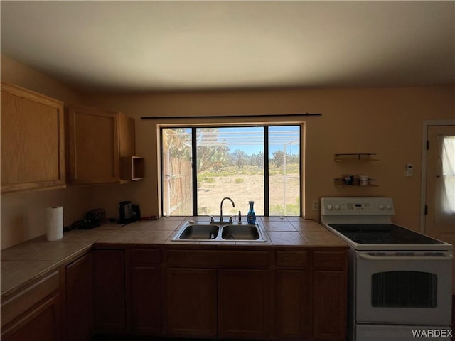 kitchen featuring tile countertops, open shelves, electric range, and a sink