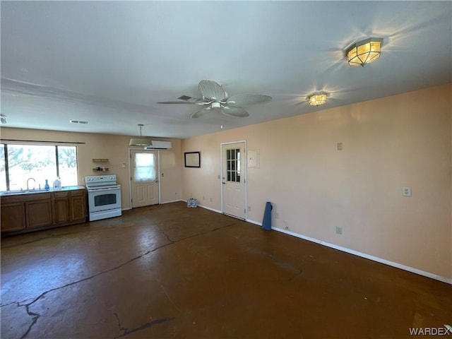 unfurnished living room featuring baseboards, a sink, visible vents, and finished concrete floors