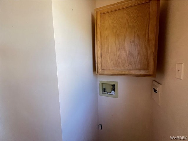 clothes washing area featuring hookup for a washing machine and cabinet space