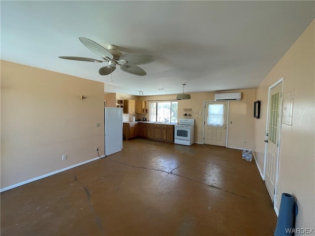 kitchen featuring a wall unit AC, concrete floors, electric stove, freestanding refrigerator, and brown cabinetry