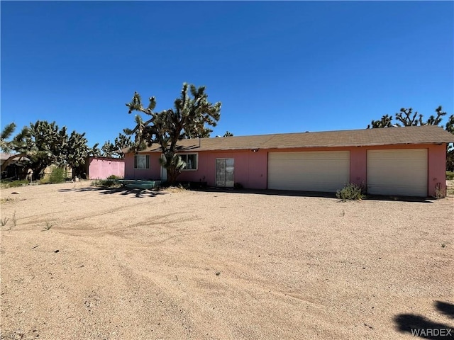 view of front of home featuring a garage and dirt driveway