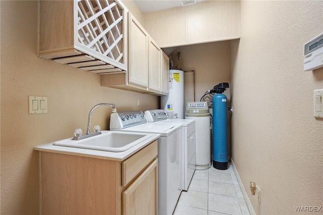 laundry area with light tile patterned floors, water heater, cabinet space, washing machine and dryer, and a sink