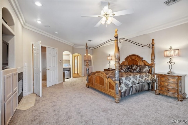 bedroom featuring arched walkways, light carpet, visible vents, and crown molding