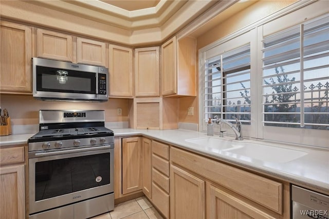 kitchen with stainless steel appliances, light countertops, and light brown cabinetry