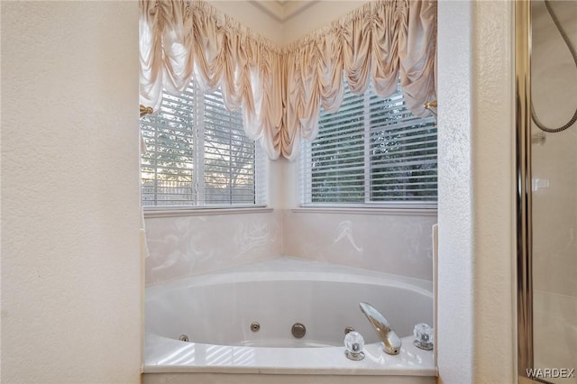 bathroom featuring a whirlpool tub and a shower with door