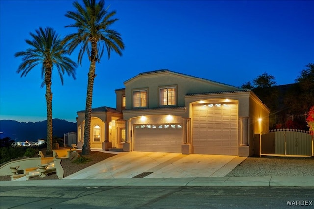 view of front of house featuring concrete driveway, a gate, and stucco siding