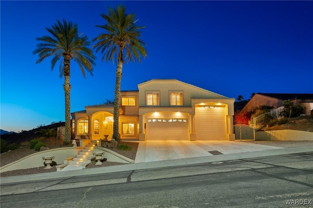 view of front facade featuring a garage, concrete driveway, and stucco siding