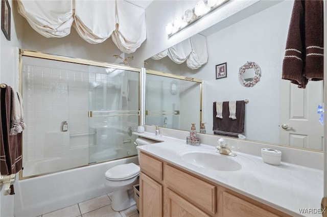 bathroom with vanity, shower / bath combination with glass door, tile patterned flooring, and toilet