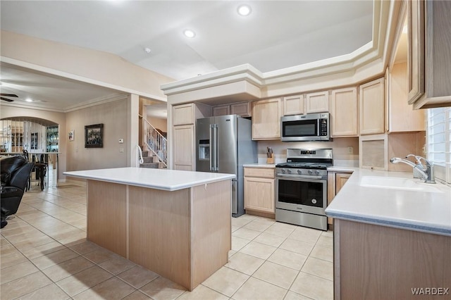 kitchen with open floor plan, stainless steel appliances, light countertops, and a center island