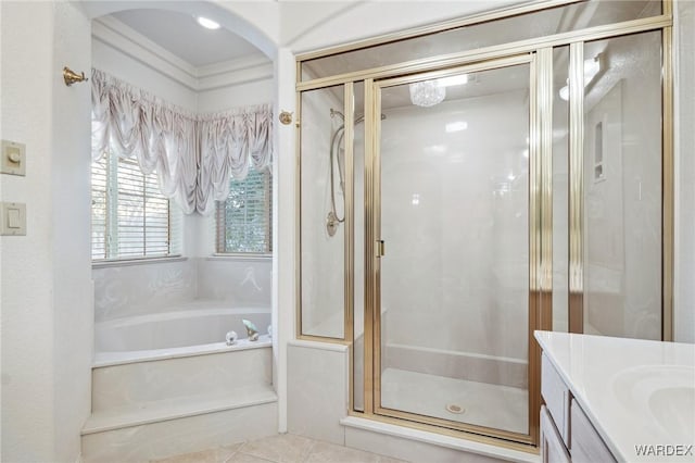 bathroom with tile patterned flooring, a shower stall, a bath, and vanity