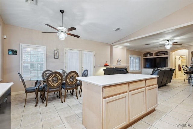 kitchen featuring arched walkways, visible vents, open floor plan, light countertops, and light brown cabinetry