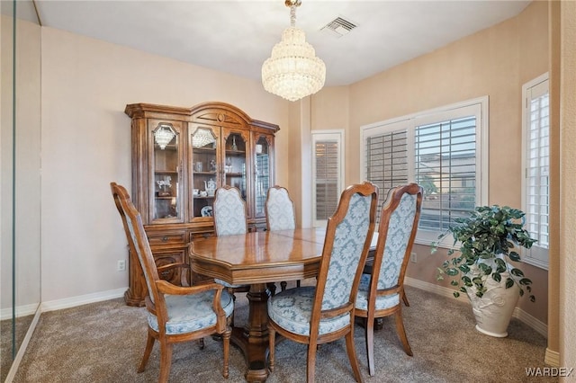 carpeted dining area featuring an inviting chandelier, baseboards, and visible vents