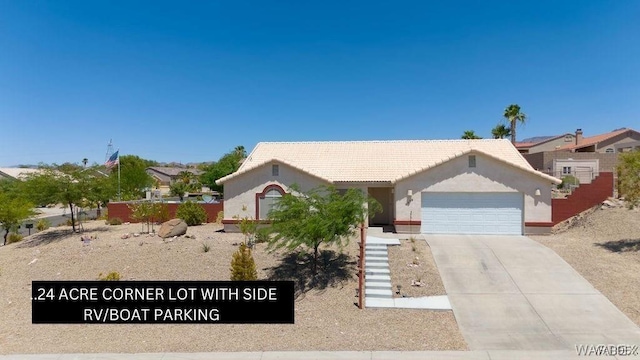 ranch-style home featuring concrete driveway, a tiled roof, an attached garage, and stucco siding