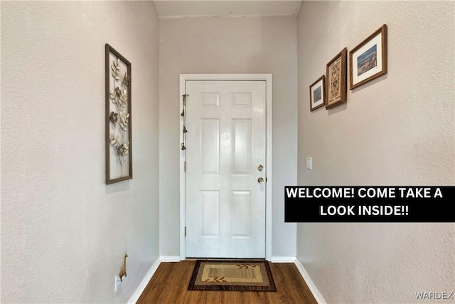 doorway to outside with baseboards and wood finished floors