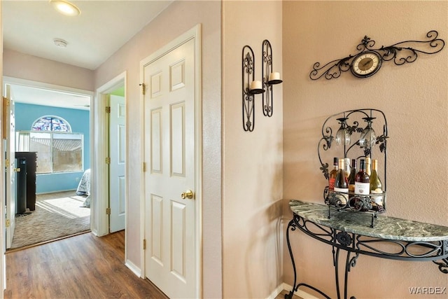 hallway with baseboards and wood finished floors