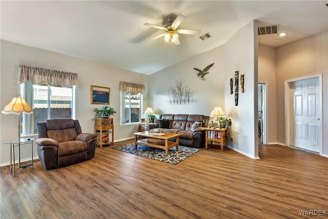 living room with lofted ceiling, baseboards, visible vents, and wood finished floors