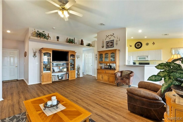 living area featuring visible vents, vaulted ceiling, and light wood-style flooring