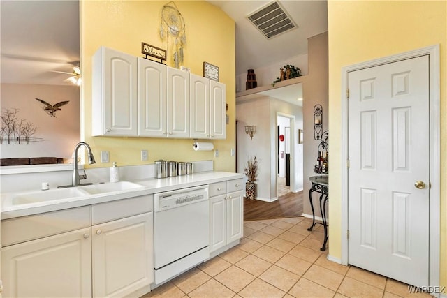 kitchen with visible vents, white cabinets, white dishwasher, light countertops, and a sink