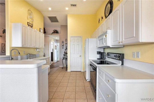 kitchen with range with electric stovetop, light countertops, visible vents, white microwave, and white cabinetry