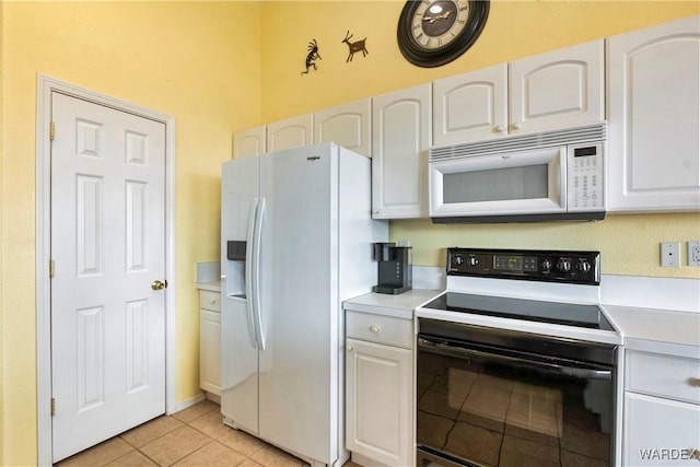 kitchen featuring light countertops, white appliances, white cabinetry, and light tile patterned flooring