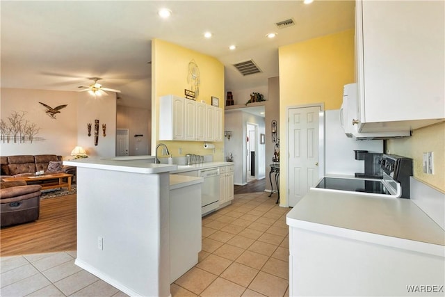 kitchen with visible vents, range, open floor plan, a peninsula, and white dishwasher