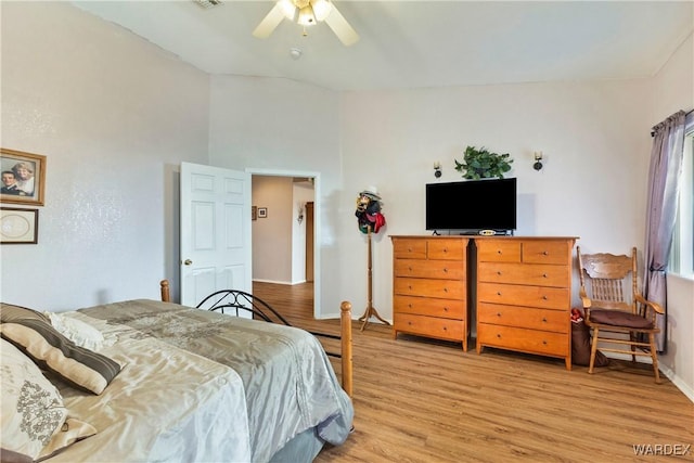 bedroom featuring visible vents, baseboards, lofted ceiling, ceiling fan, and light wood-type flooring