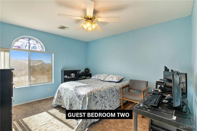 carpeted bedroom featuring a ceiling fan, visible vents, and baseboards