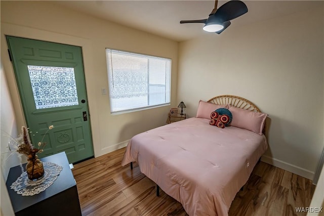 bedroom with a ceiling fan, light wood-style flooring, and baseboards