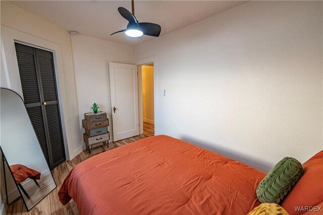 bedroom featuring a closet, ceiling fan, baseboards, and wood finished floors