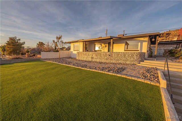 back of property featuring a lawn and stucco siding