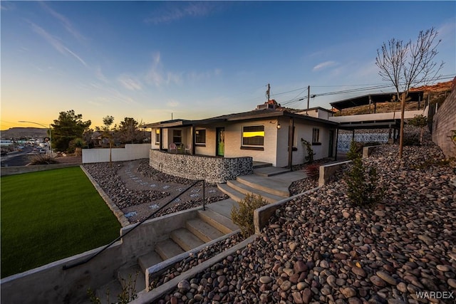 view of front of property featuring brick siding, a lawn, and fence