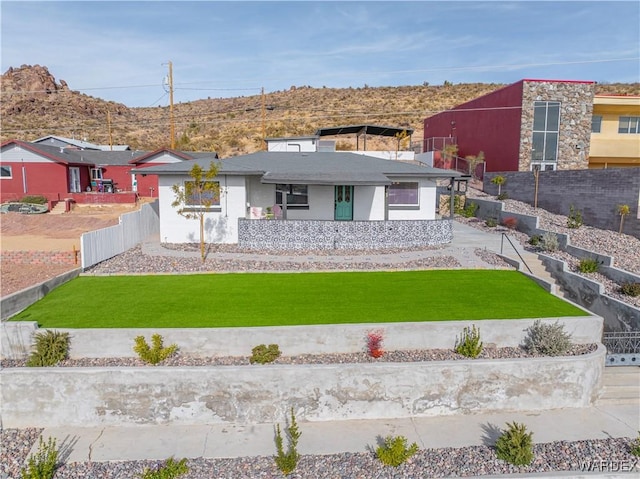 view of front of home with fence private yard and a front lawn