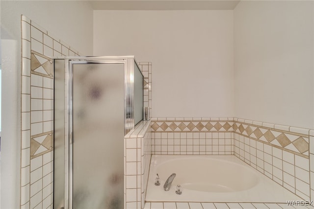 bathroom featuring a shower stall and a garden tub
