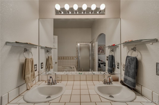 full bathroom with a garden tub, double vanity, and a sink