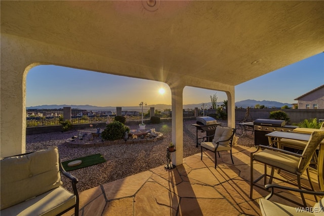 view of patio with a grill, a mountain view, and a fenced backyard