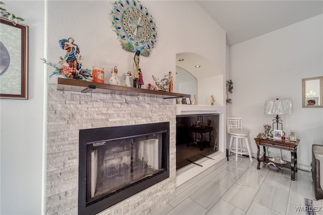 living room with a fireplace, marble finish floor, and vaulted ceiling