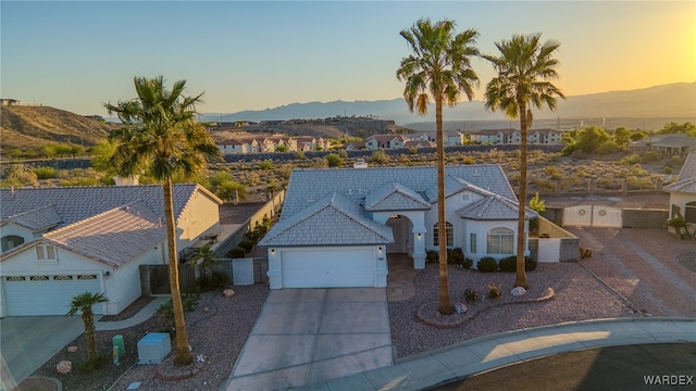 ranch-style house with an attached garage, driveway, and a mountain view