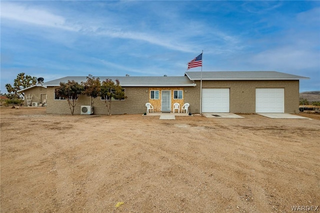 view of front of house featuring a garage, ac unit, and driveway