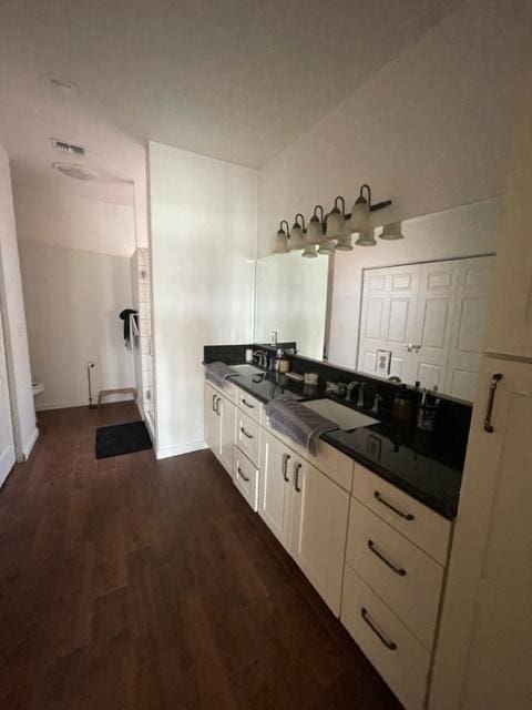 bathroom with a sink, wood finished floors, toilet, and baseboards