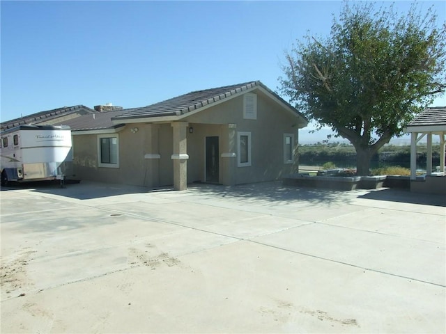 view of front of property featuring driveway, stucco siding, and a tiled roof