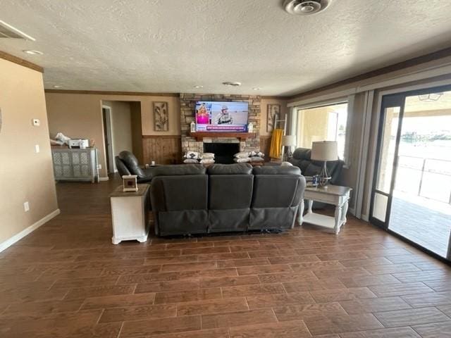 living area with a fireplace, a textured ceiling, and baseboards