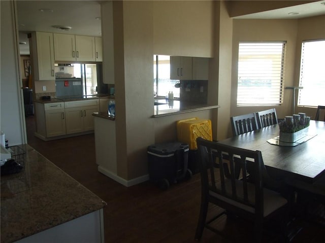 dining area featuring dark wood finished floors and baseboards